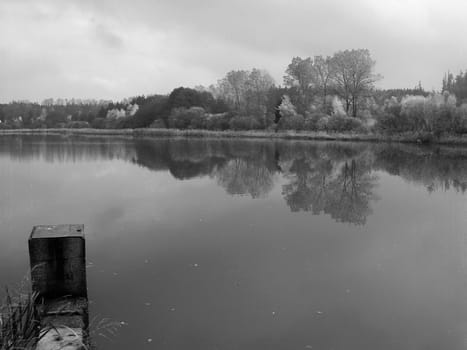 Sad autumn scenery with lake in black and white tones
