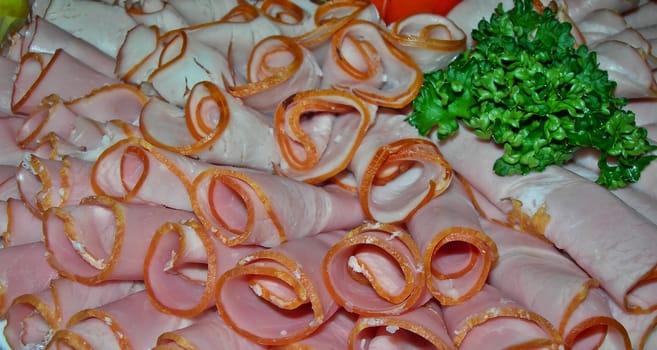 Decorative cold dish with rolled ham and parsley      