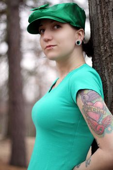 lady in green hat with tattoos in the woods
