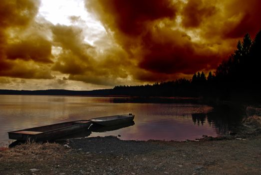 Beautiful sunset over a lake with ship and a dramatic sky 