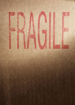 Closeup of a brown cardboard box with word "Fragile" stamped with red ink.