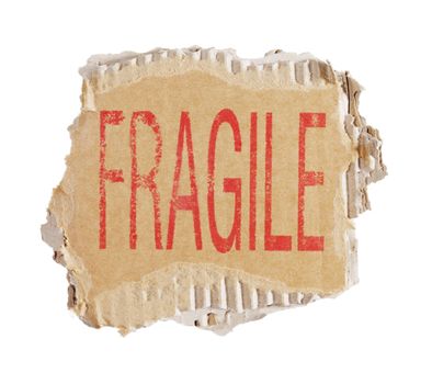 Word Fragile stamped on a piece of brown corrugated cardboard.