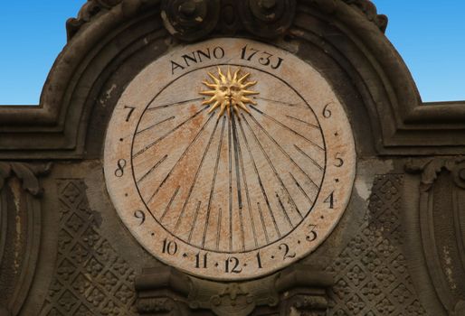 Sundial on the the wall. Measures time via shadow