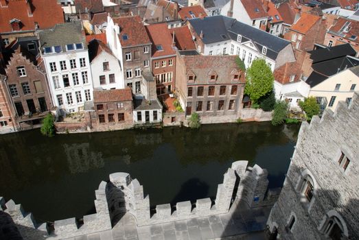 gabled houses along a canal in Gent, Belgium with reflection on the water seen from the castle