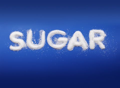Word Sugar written with real fine granulated sugar on blue background.