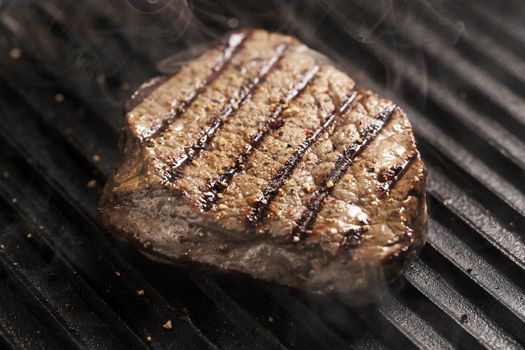 Beef tenderloin steak with pepper on a grill pan. 