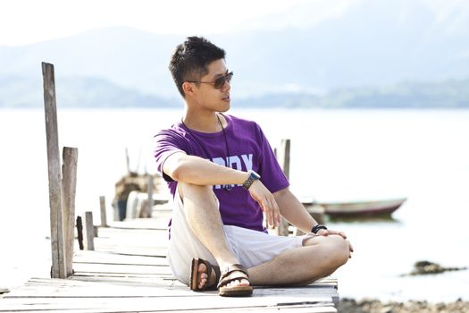 Asian man sit on wooden bridge