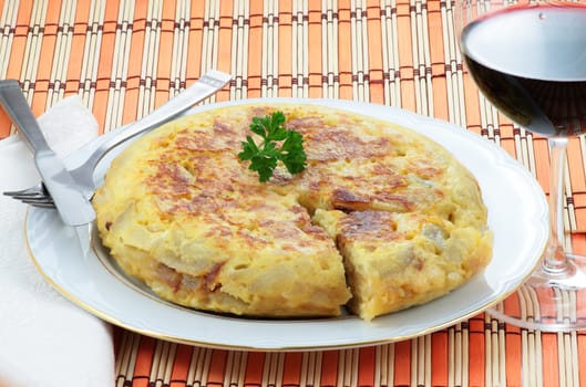 spanish omelet of potatoes and onion with a glass of red wine