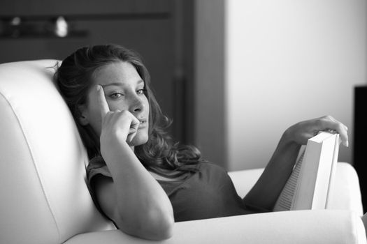 Portrait of a young beautiful woman reading a book