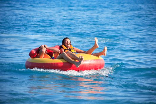 Laughing teenage boy and girl in inner tube after driving