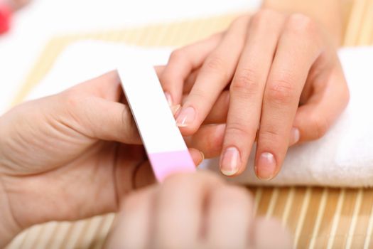 Young woman is getting manicure in a beauty salon