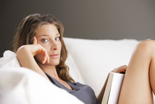 Portrait of a young beautiful woman reading a book