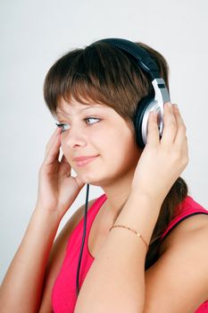Attractive teenage girl listening to music on headphones