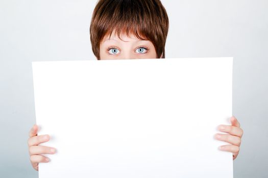 young girl hiding behind a white banner