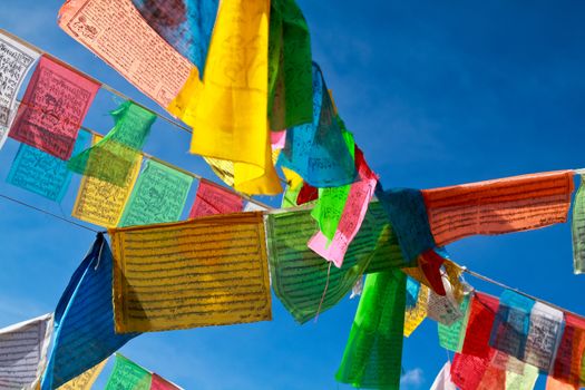 Buddhist tibetan prayer flags flying with blue sky