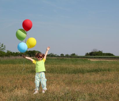 happy little girl with colorful balloons