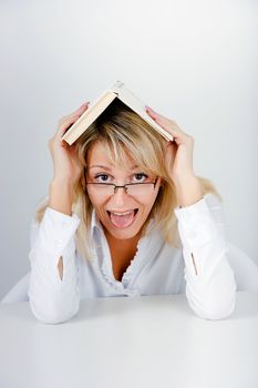 funny blonde hidden under a book in the office