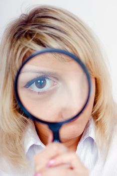 young woman looking through a magnifying glass