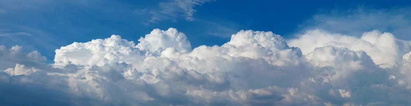 A panoramic shot of fluffy white cumulus clouds in the sky