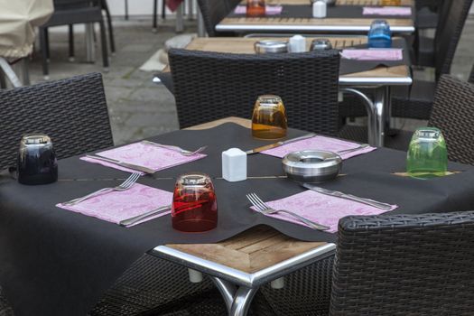 Image of a beautiful and colorful Venetian street restaurant terrace with rattan chairs.