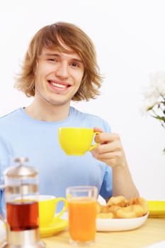 Young happy man drinking tea at home