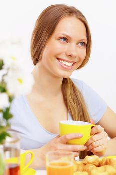 Beautiful young woman drinking tea from yellow cup