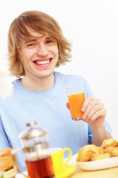 Young happy man smiling and drinking juice