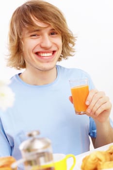 Young happy man drinking tea at home