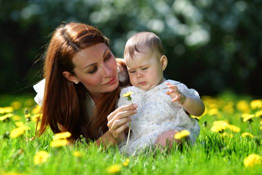 Happy mother and daughter on the green grass