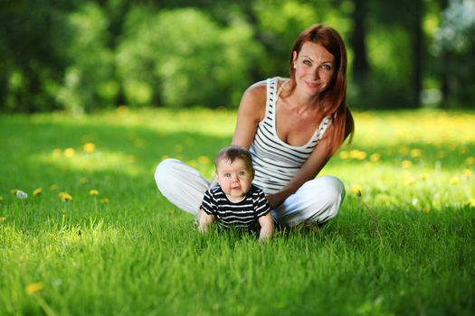 Happy mother and daughter on the green grass