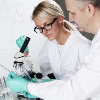 two scientist in chemical lab conducting experiments