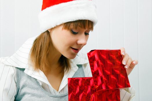 Attractive girl opens a Christmas present. office scene