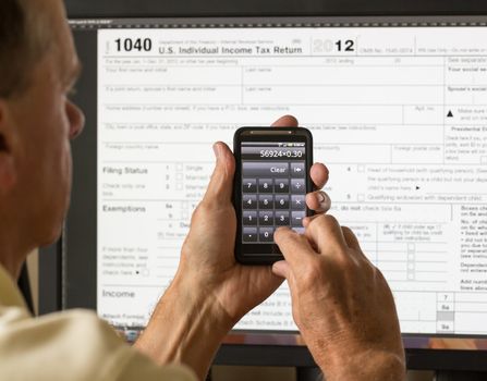 Electronic tax form 1040 for 2012 for US individual return on screen with smartphone calculator