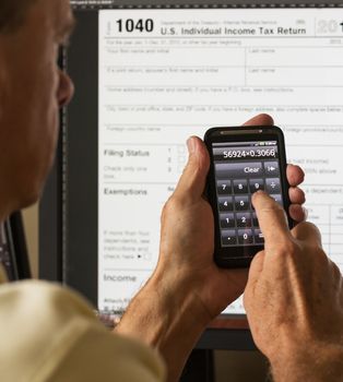 Electronic tax form 1040 for 2012 for US individual return on screen with smartphone calculator