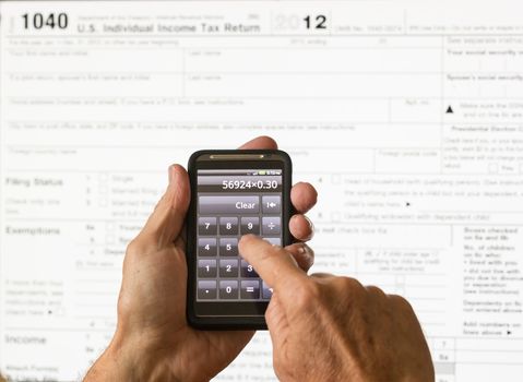 Electronic tax form 1040 for 2012 for US individual return on screen with smartphone calculator