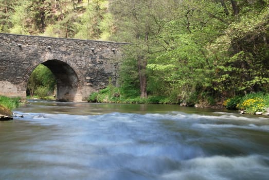   Ancient stone bridge over the river Strela in the Czech Republic        