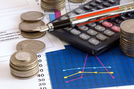 calculator, pen and cooins on sheet of financial data