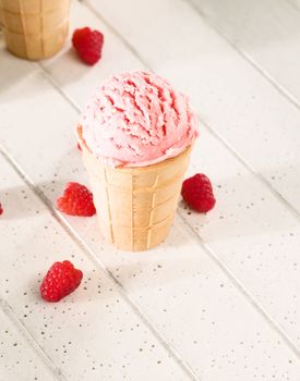 one raspberry ice cream on white wooden background from top