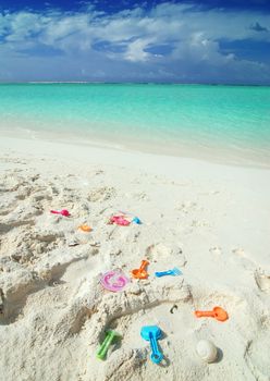 Colorful child toys laying on the beach in the Maldives