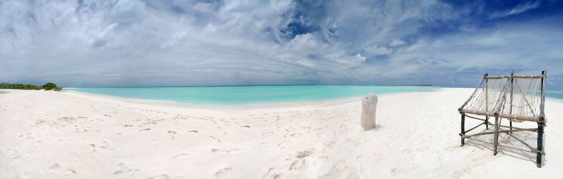 Two old cane chairs on the tropical beach in the Maldives -ultrawide panorama