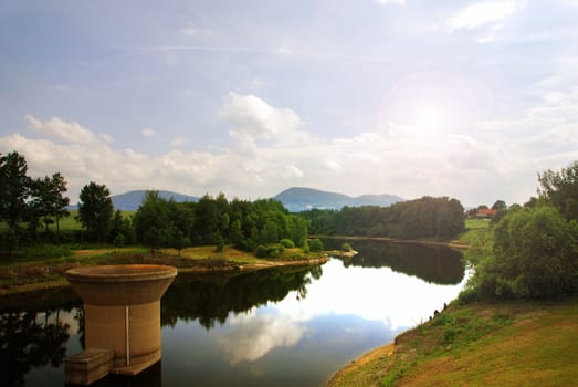 Silent river in the Czech country with a remains of an old bridge