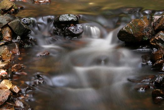 Hidden mountain brook with stones and  long exposure