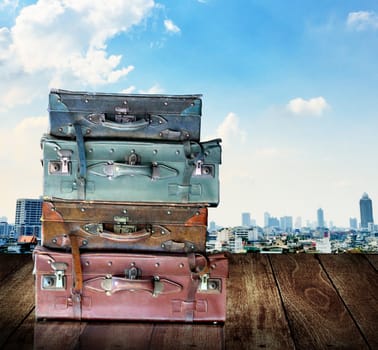 Vintage travel luggage on wooden wall with city view background