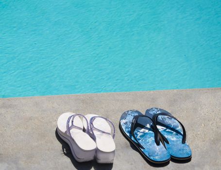 Women's and men's flip flops by the swimming pool