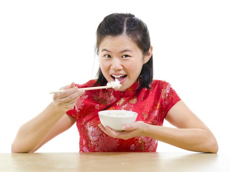 Asian woman eating rice with chopsticks over white background