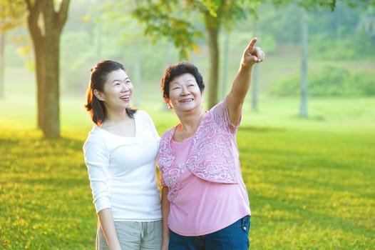 Happy Asian senior mother with her daughter at outdoor park