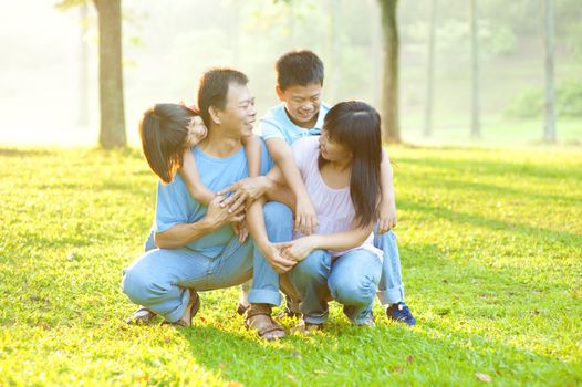 Happy Asian family having conversation at outdoor park