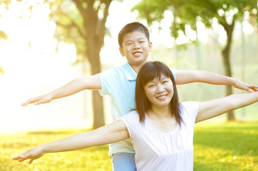 Asian mother and child happy playing on tropical park