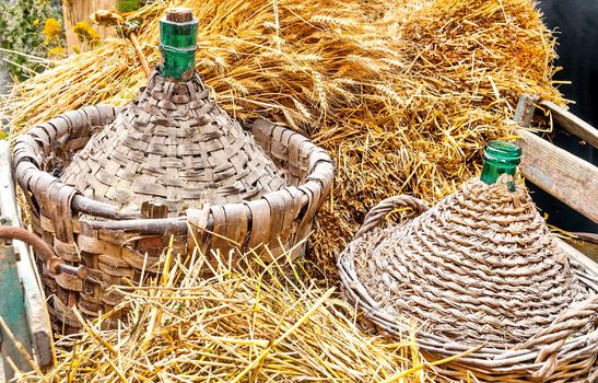 Autumn harvest demijohn wicker with bales of hay