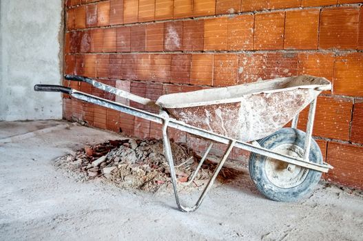 wheelbarrow after building a brick wall in a workplace